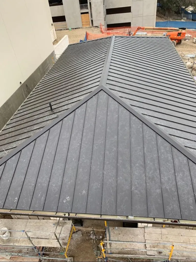 Commercial metal roof construction with crane equipment in Pewaukee